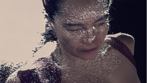 early technology 3D head scan of Zuzana's face, looking like a lot of dots, augmented with modern AI to show her torso and fill in a mostly empty space around her.