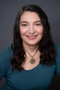 Zuzana Gedeon Headshot in Dark turquoise shirt and necklace