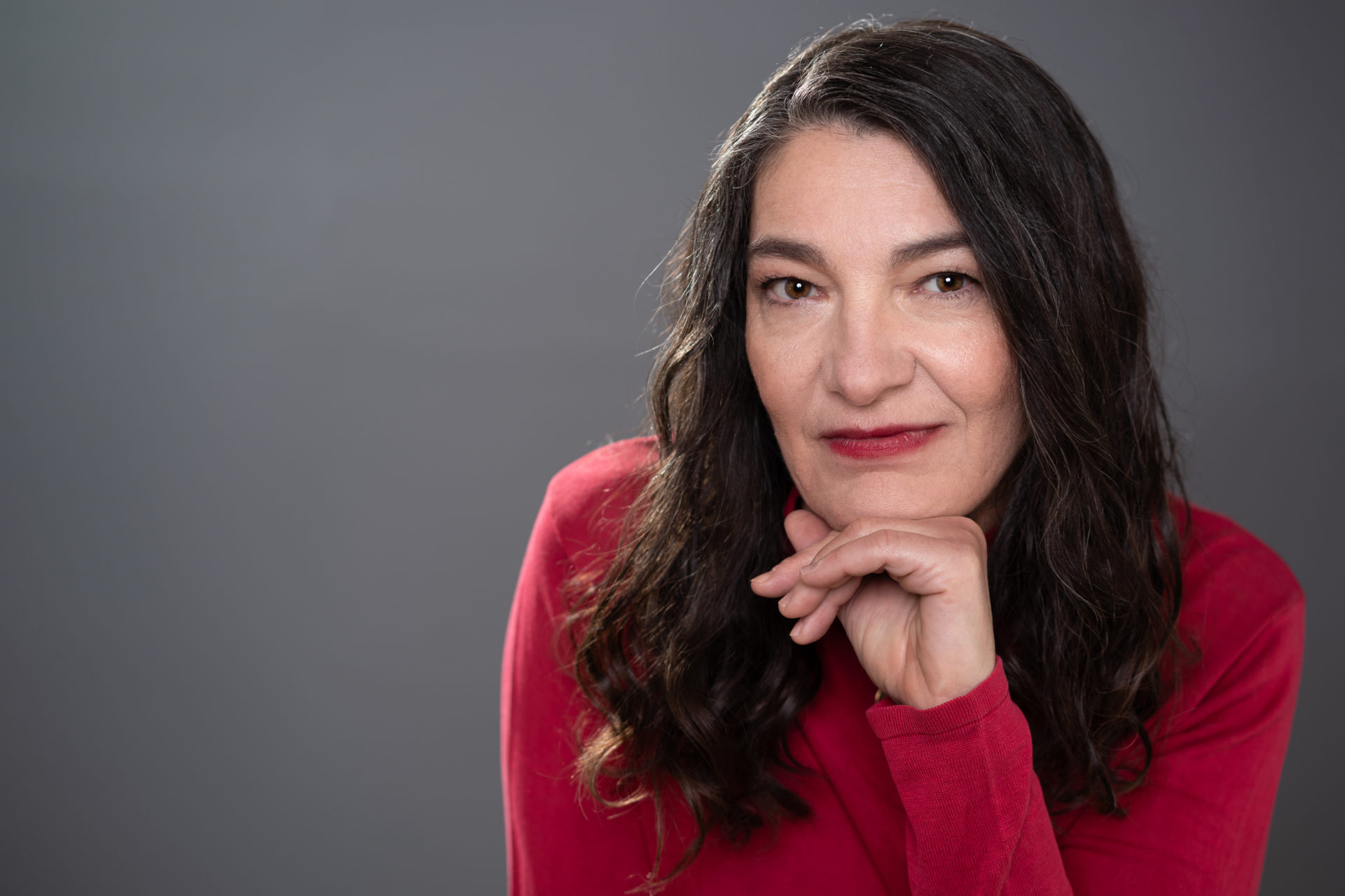 Zuzana Gedeon Headshot in red turtleneck.